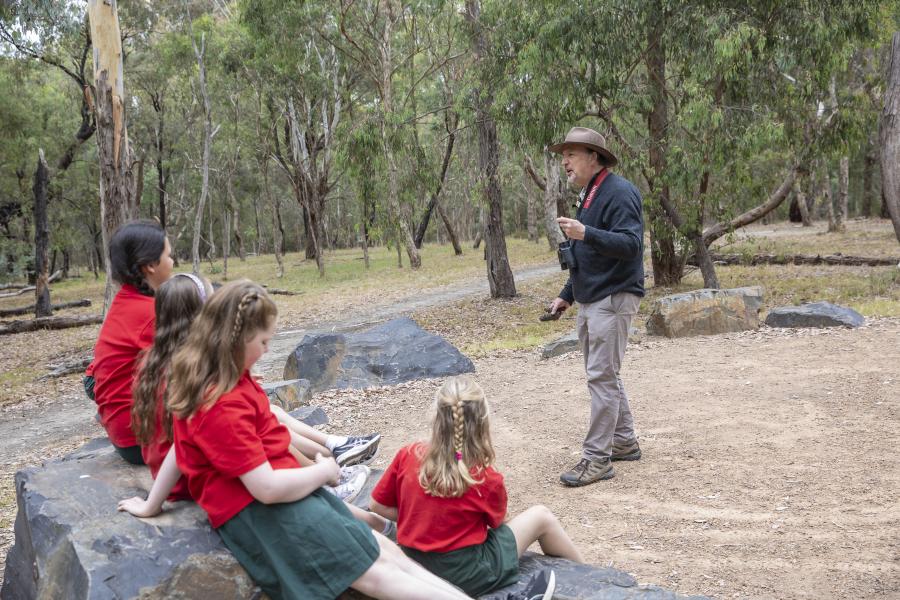 Primary school students listening to a speaking at the Yarning circle Blackburn Lake Sanctuary