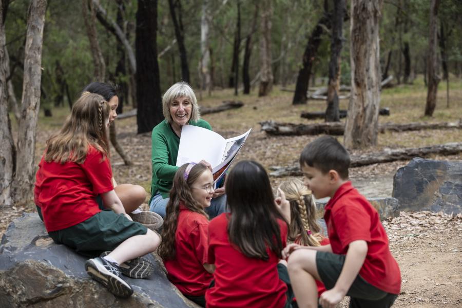 Volunteer reading a story at the Yarning Circle at Blackburn lake Sanctuary