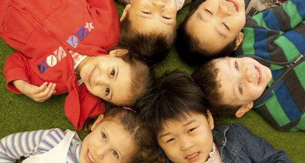 A group of multicultural children laying on the ground