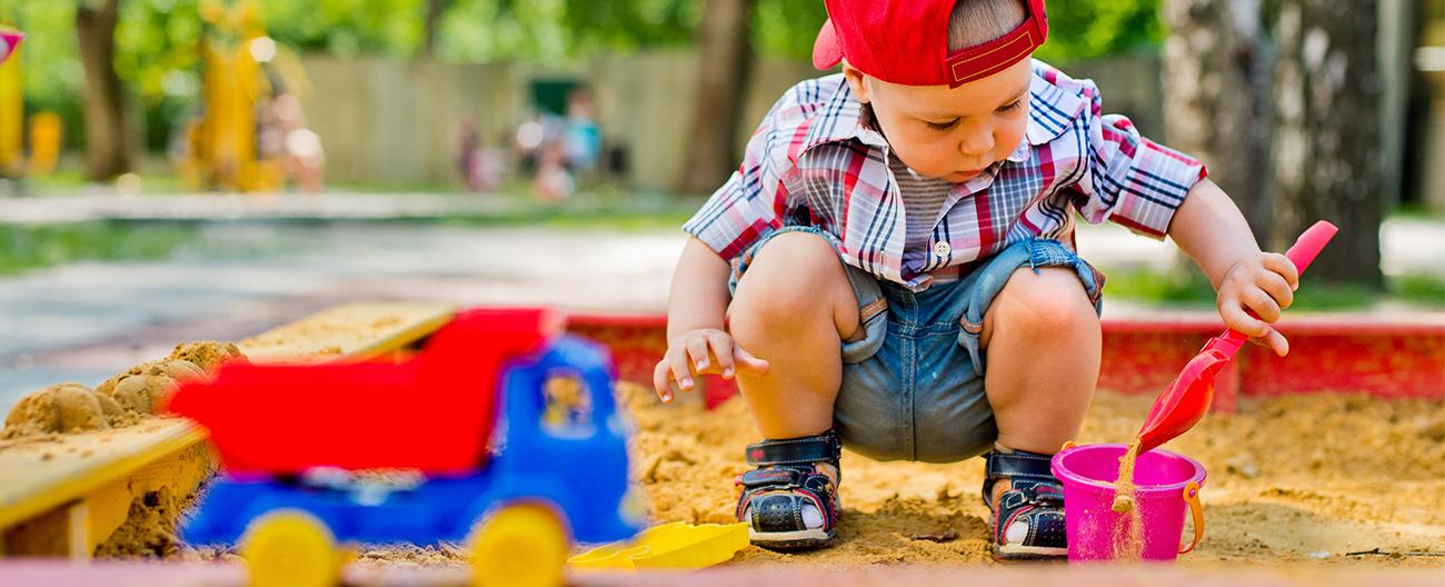 A little boy playing in a sandpit
