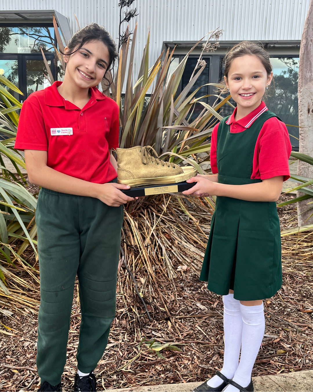 2 girls holding a golden boot