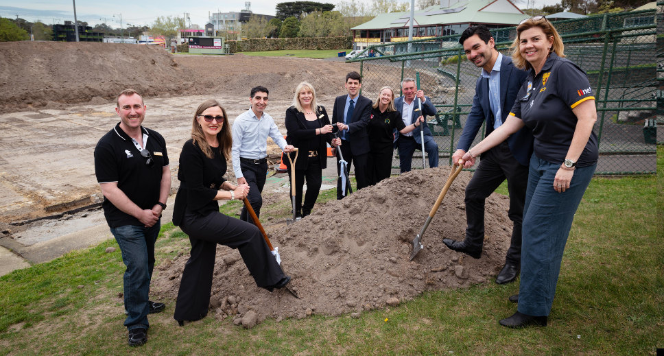 people standing around a pile of dirt with shovels