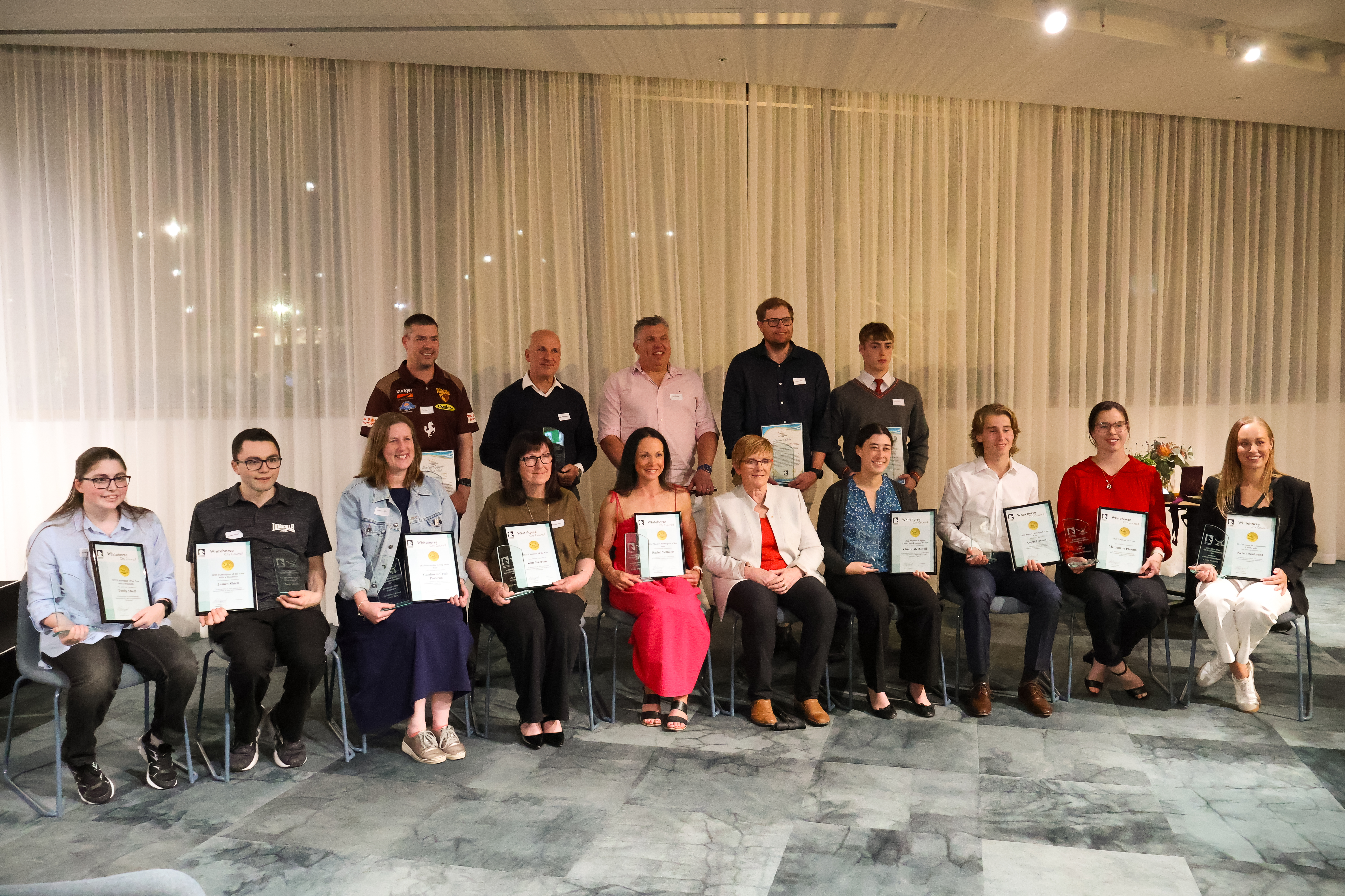 a group of people all holding awards and framed certificate