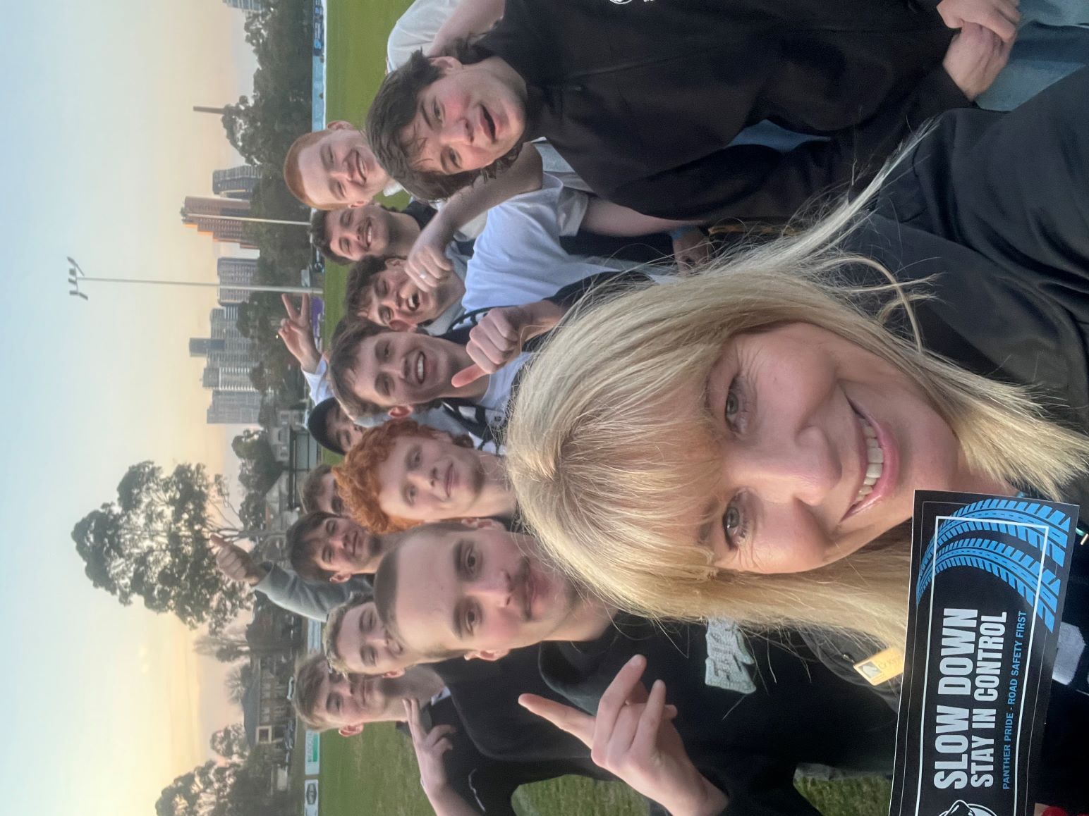 Cr Langford and a football team holding stickers