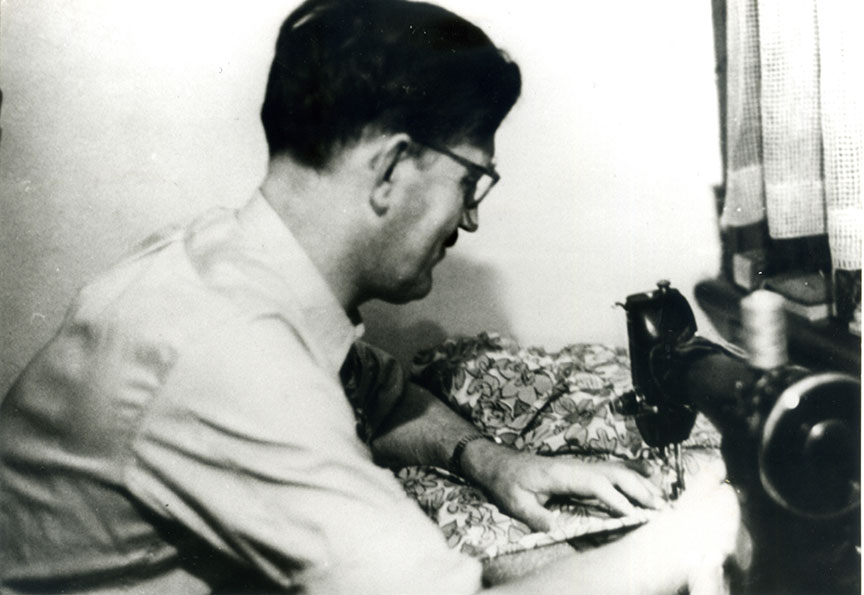 Black and white photo of man using sweing machine