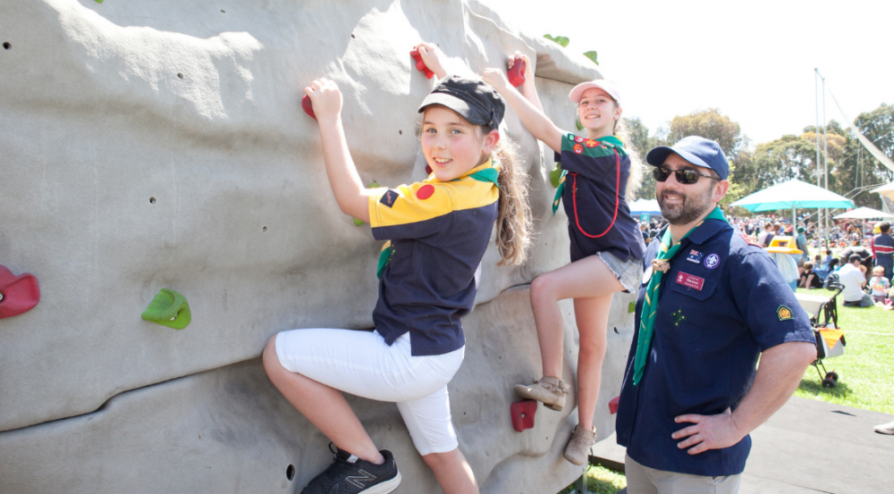 a man and two kids wall climbing