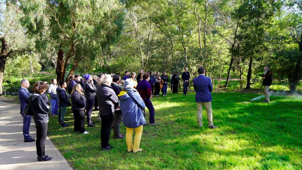 Attendees of GCRC standing in a group beside smoking ceremony