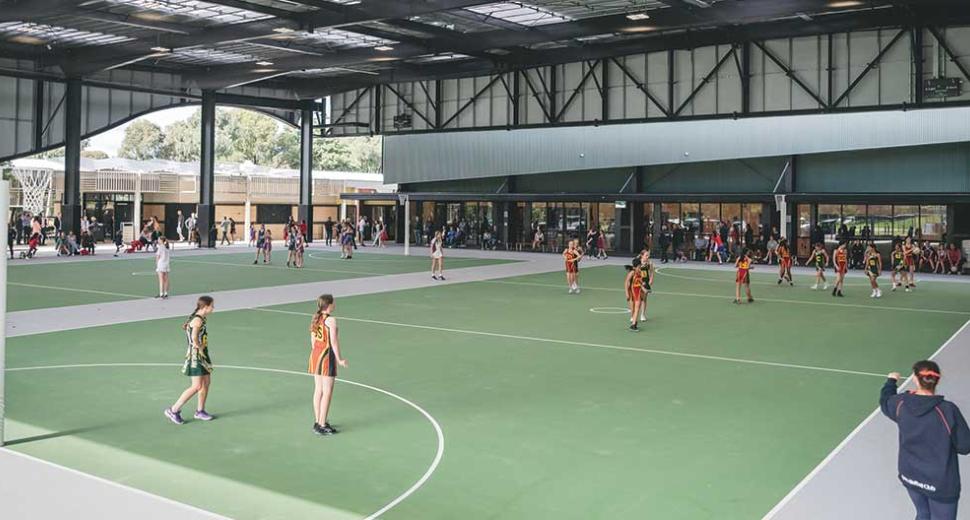 Sportlink stadium showing undercover netball courts with a match