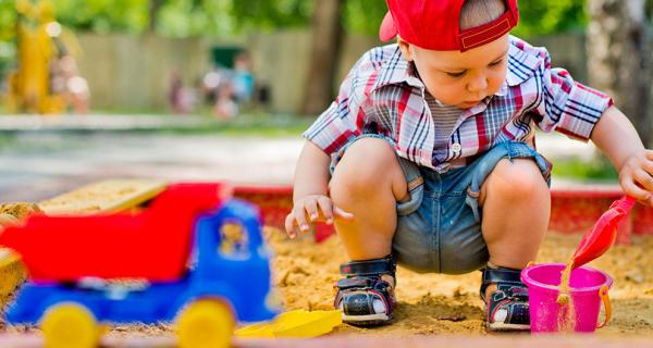 A little boy playing in a sandpit
