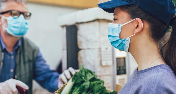 lady delivery vegetables to older man