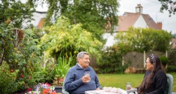 Man and lady talking at outdoor picnic table