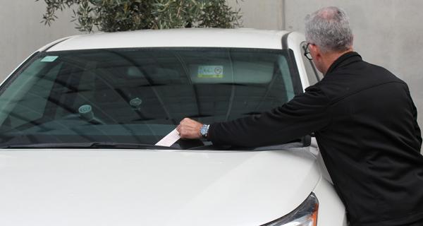 Parking fine being placed on car windscreen
