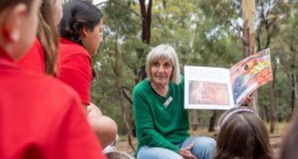 a person reading to a group of students