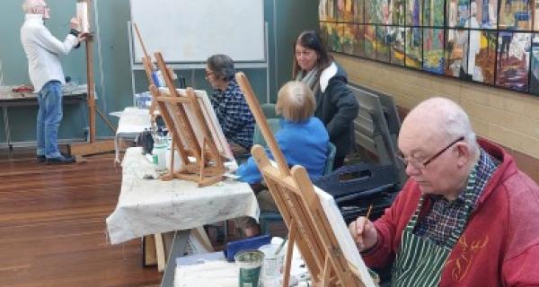 Senior man and community painting in art room