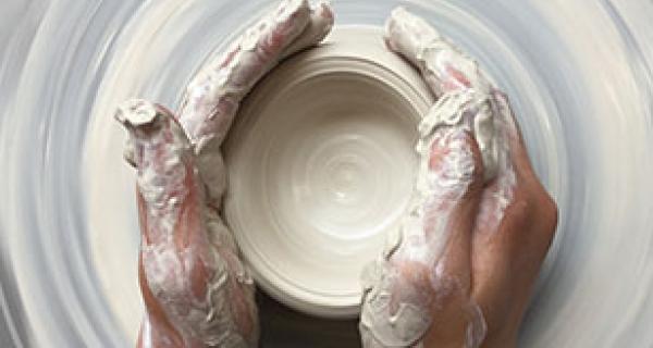 hands working with clay on pottery wheel