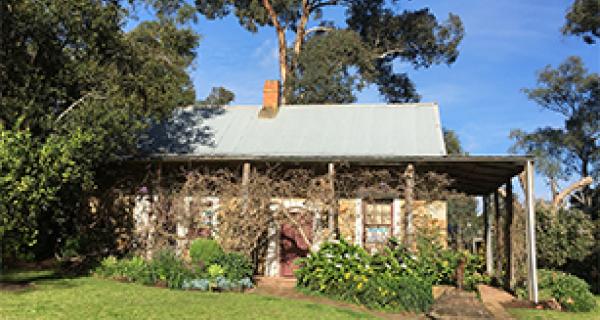 Outside picture of Schwerkolt cottage surrounded by the green of trees and grass