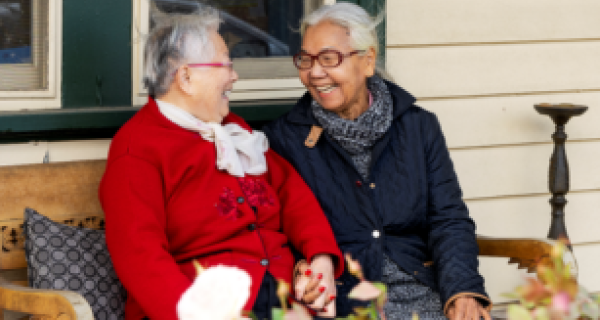 2 ladies sitting and smiling