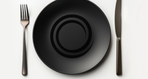 Empty black plate with knife and fork on either side