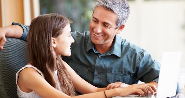 Father and daughter sharing laptop