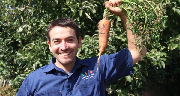 Duncan from Leaf, Root and Fruit holing up a large carrot