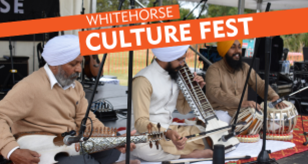 3 men playing traditional indian instruments on outdoor stage