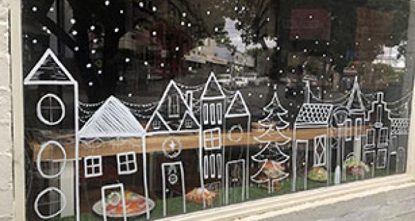 shop front window decorated with festive chalk drawings