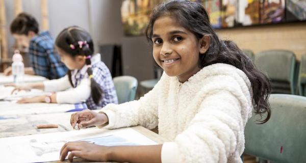 Kids creating floral still life artworks 