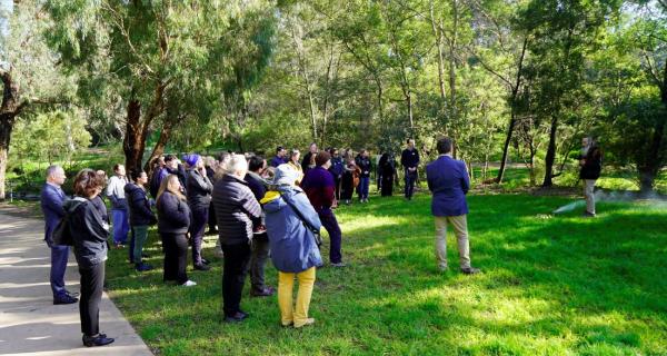 Attendees of GCRC standing in a group beside smoking ceremony