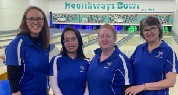 4 ladies stand in front of the bowling alley of Healthways