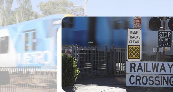 Train crossing a level crossing with gates down and lights flashing