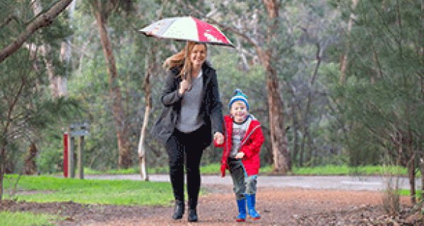 Mother and son walking with umbrella