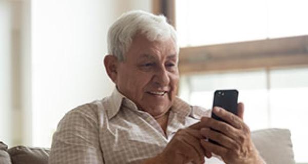 smiling older man holding phone
