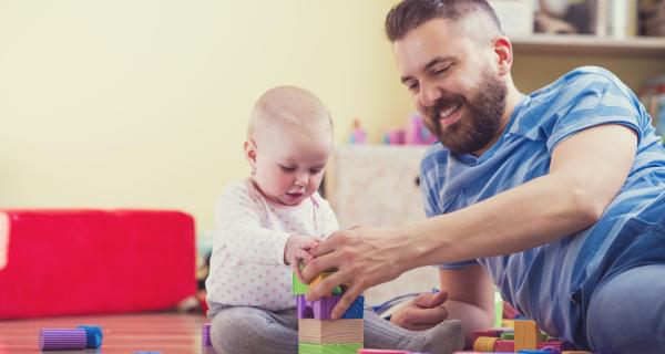 Father on floor playing with young child