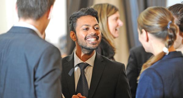 A young Asian bussineman taking to a group of people