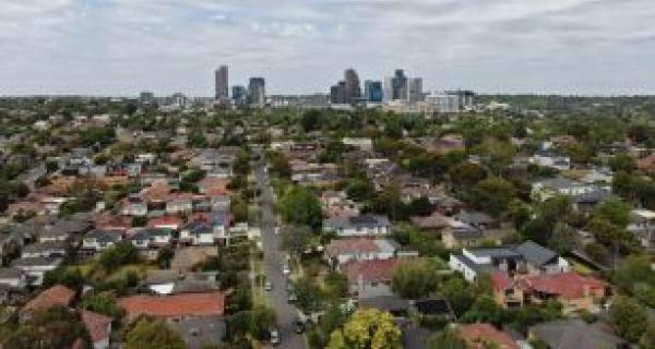 A city scape showing houses spreading out to high buildings in background of photo. 