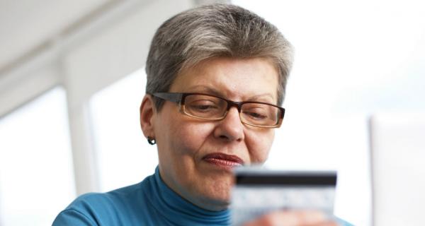 Older woman using credit card online paying bill