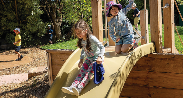 2 children on a playground slide