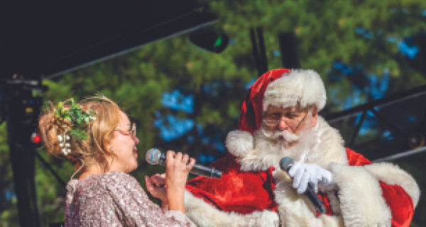female singing on microphone with santa