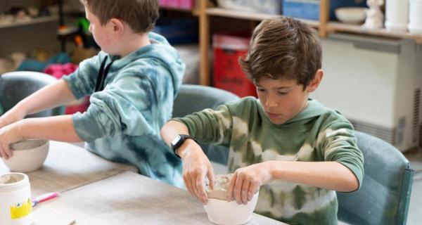 Kids making clay bowls 