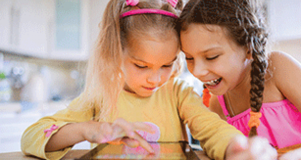 Two girls interacting and smiling at screen