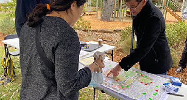 People standing around and discussing an East Burwood reserve map