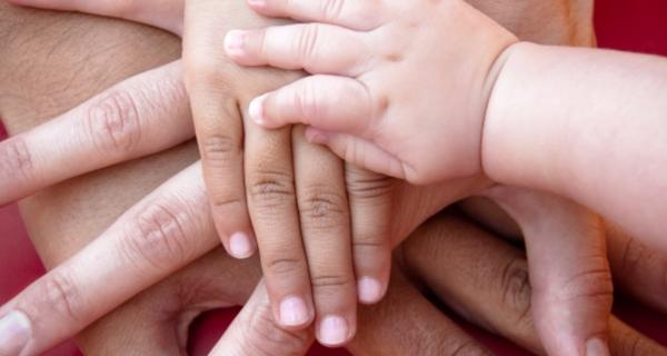 Parents and baby's hands stacked on top of each other