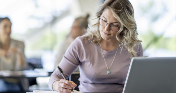 a person sitting at a table writing