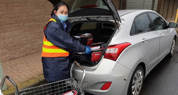 Woman making delivery from back of car