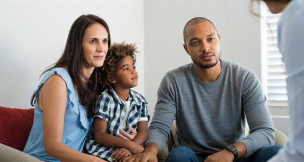 Mother with child on lap, with father sitting beside them providing comfort