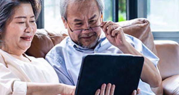 2 older people looking at a table device