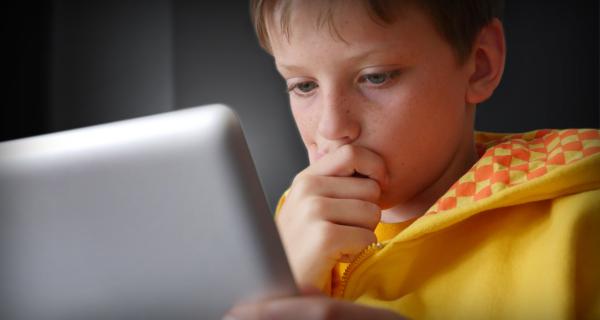 Young boy looking concerned at his laptop screen
