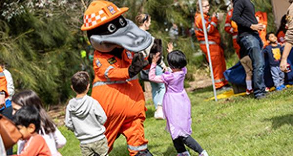 Person dressed in animal costume gives girl high five