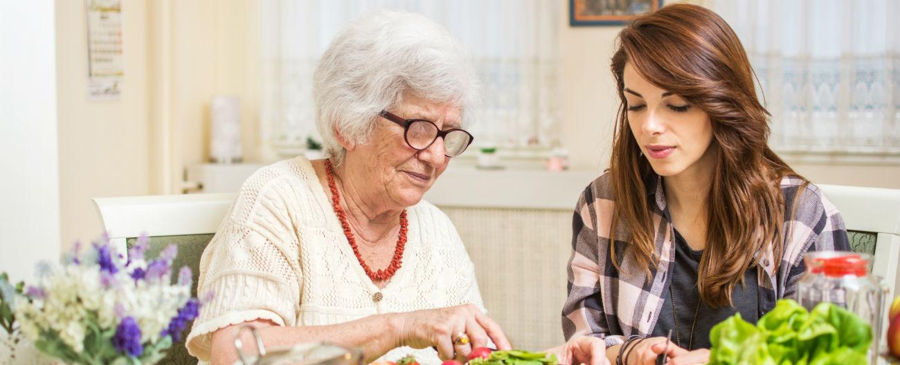 Older woman and support worker preparing food