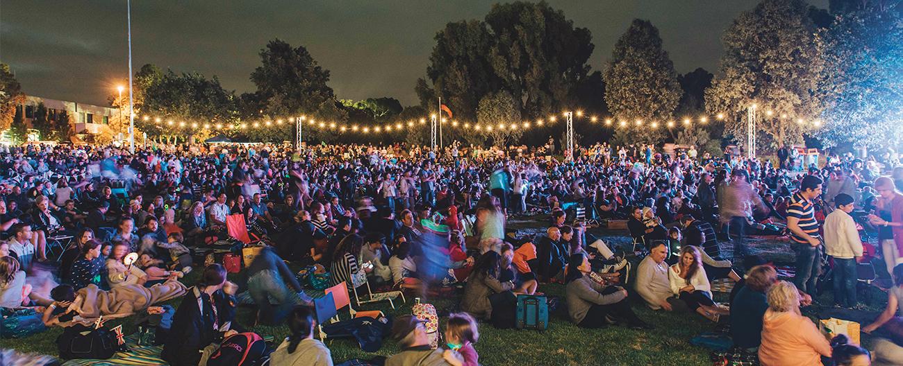 Community gathering at night with festoon lighting